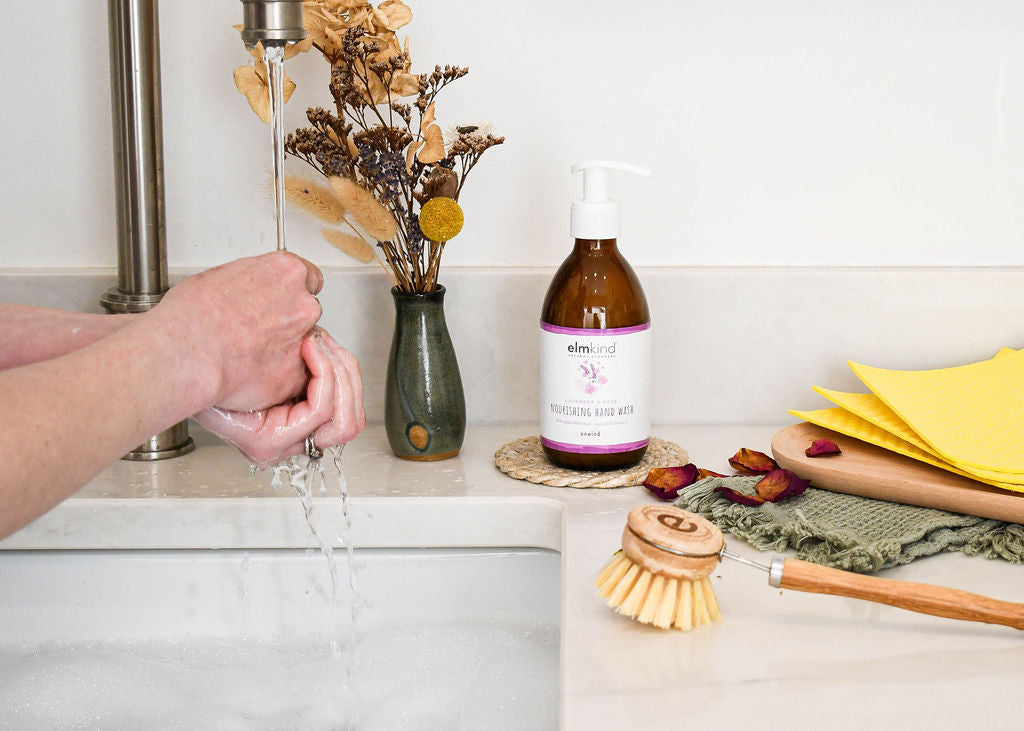 a woman washing her hands with elmkind plant based hand wash